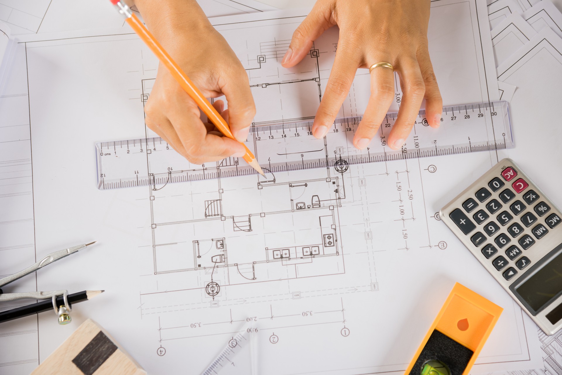 Architect drawing with ruler on house plan blueprint paper for repair tools on table